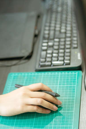 hand is caught pen mouse and is currently in use.To work for the design and use of business and technology are working at the Office.の写真素材
