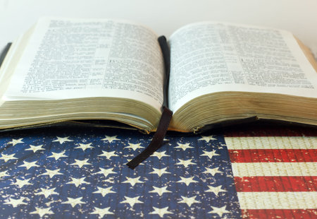 An old Bible with a July 4th background and an American Flag with room for copy space