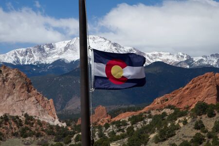 Colorado State Flag with Pikes Peak and Garden of the Gods in the background on a spring dayの写真素材