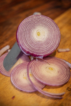 Sliced Red Onions on a Butcher Block Surface with a stainless steel knife