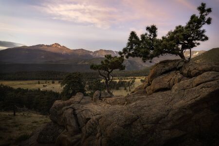 The peak of Longs Peak Mountain glows in the morning sunlight on a September morning in Rocky Mountain National Parkの写真素材