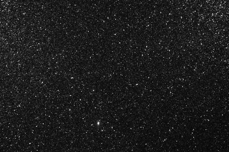 Glittering black background. Twinkling particles of glitter.の写真素材