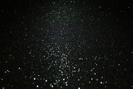 Glittering black background. Twinkling particles of glitter.の写真素材
