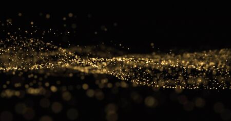 Golden glitter wave, light particles and dust glow splash, gold glittering light bokeh overlay on blackの写真素材