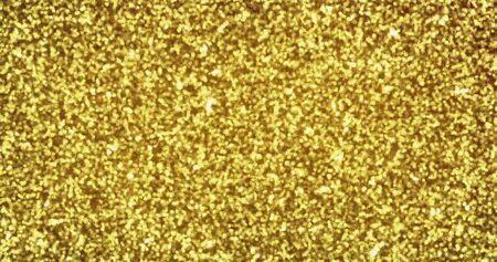 Gold glitter sparkling light shine background with golden particles texture. Shimmering sparkles and golden glowing shimmer, luxury backdropの写真素材