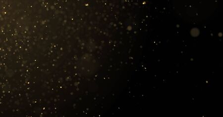 Golden glitter rain, gold particles splash on luxury black and gold background. Bokeh light and golden sparks shimmer glow flowの写真素材
