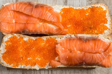 sandwiches with red caviar and salmon on wooden backgroundの写真素材