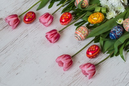 Easter Background with easter eggs and pink tulips on light wooden background.の写真素材