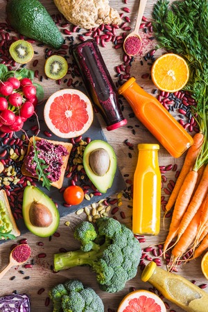 Healthy vegan food. Sandwiches and fresh vegetables on wooden background. Detox diet. Different colorful fresh juices. top viewの写真素材