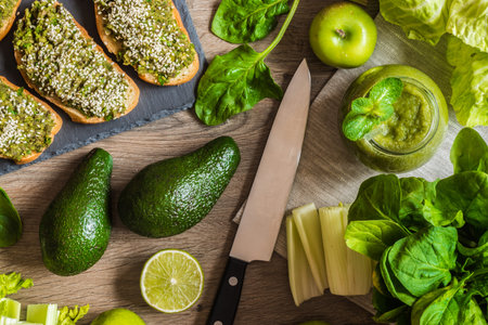 Detox diet. Green smoothie and sanwiches with avocado. Different vegetables on wooden background