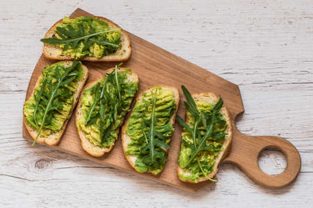 Healthy green food. Vegan sandwiches with avocado on wooden backgroundの写真素材