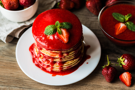 Close-up american pancakes and strawberry sauce on a wooden background. Shallow depth of field.の写真素材