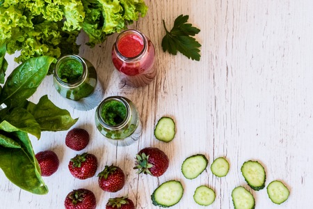 Top view. Fresh green smoothies and strawberry smoothie with ingredients on a light wooden background. Healthy detox drinks.の写真素材