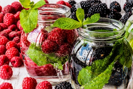 Two kinds of detox water with blackberry and strawberry on white wooden background.の写真素材