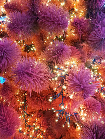 Christmas tree. A close-up of a Christmas tree. Garlands on the fur-tree close-up. Red and purple Christmas tree needles.の写真素材
