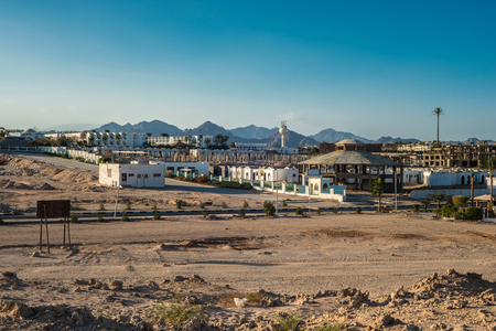 Fragment of the city of Sharm El Sheikh on the background of the Sinai mountains at sunsetの写真素材