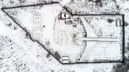 The plane is parked in the forest in winterの写真素材