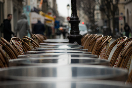 Street view of a Cafe terrace with empty tables and chairsの写真素材