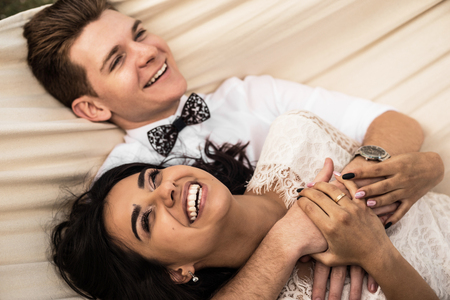 Merry happy young couple hugging in a hammock. Closeup.の写真素材