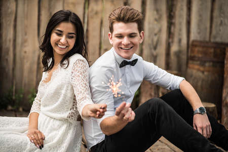 Merry happy young couple sitting on the wooden floor. Closeup.の写真素材