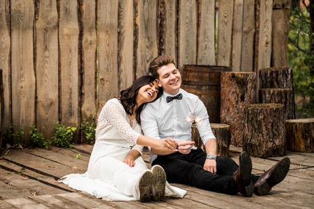 Merry happy young couple sitting on the wooden floor. Closeup.の写真素材