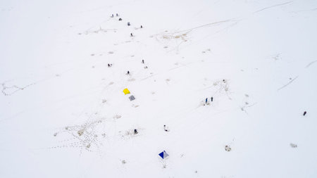 Aerial view of winter fishing. Fishermen set up tents for fishing at night.