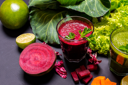 Healthy drink with fruits and vegetables on the black wooden background.の写真素材