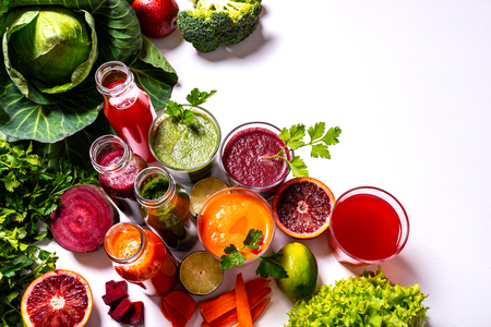 Different healthy vegan drinks with fruits and vegetables on the white wooden background. Flat lay.の写真素材