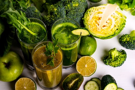 Vegan food and drinks with spinach, kiwi and cucumber on the white wooden background. Raw drinks and foods.の写真素材