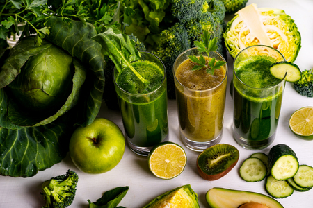 Vegan food and drinks with spinach, kiwi and cucumber on the white wooden background. Raw drinks and foods.の写真素材