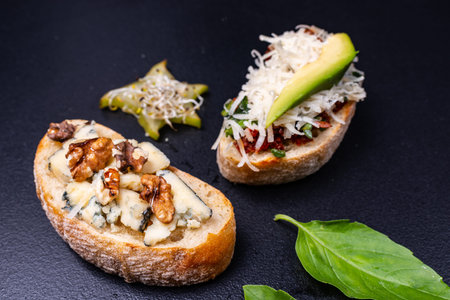 Appetizer bruschetta with cheese, honey, walnut and other ingredients on black background. Close-up....