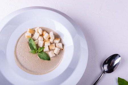 Mushroom cream soup in a white plate and on a white backgroundの写真素材
