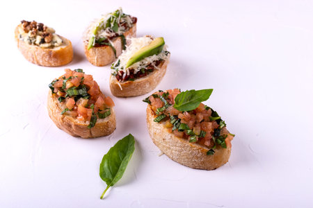 Set of assorted bruschetta with various toppings for holiday on white background. Top view. Party...