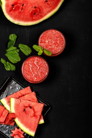Watermelon smoothie fresh juice with mint and pieces in the shape of stars on a black background. Summer healthy drinks. Top view.の写真素材
