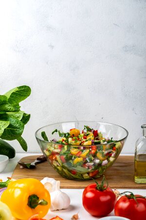 Bowl full of salad from different eco vegetables with ingredients and spices on the table. Healthy diet food concept.の写真素材