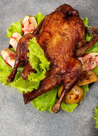 Roasted duck with apples, herbs on a grey background. Christmas symbolic food. Top viewの写真素材