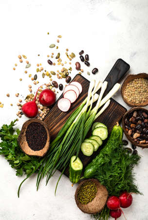 Raw vegetables greenery cereals beans on the chopping boardの写真素材