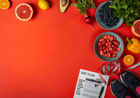 Weight loss program Fitness equipment Fresh food on red background. Top view with copy space.の写真素材
