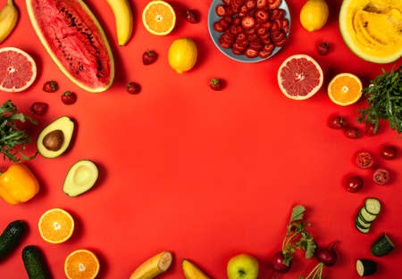 Frame of fruits and vegetables on the red background. Top view with copy spaceの写真素材