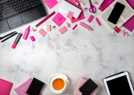 Female workspace with pink office accessories and gadgets. Top view.の写真素材