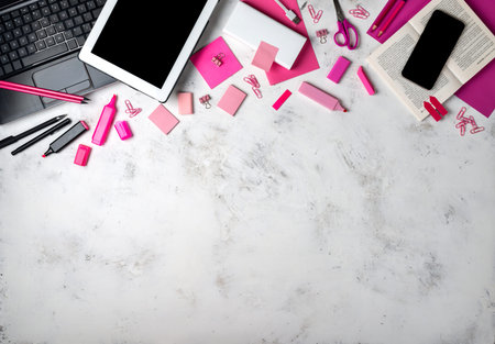 Female workspace with pink office accessories and gadgets. Top view with copy space