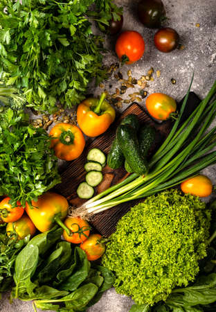Vegan menu set. Organic vegetables and greens with chopping board on the table.の写真素材