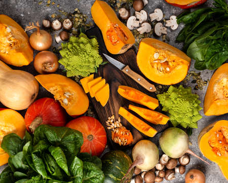Sliced squash and chopped pumpkin with different vegetables on the table.の写真素材