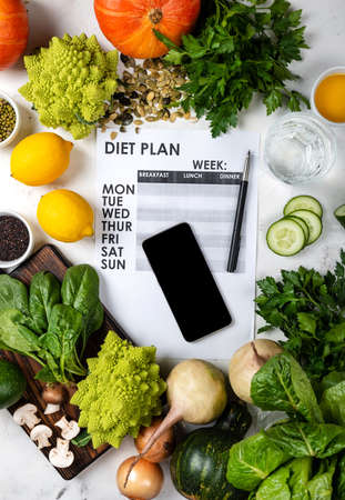 Lose weight concept. Smartphone Diet plan and set of healthy foodの写真素材