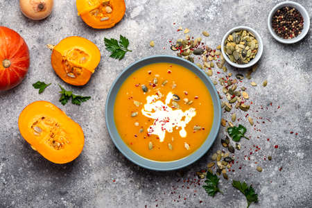Bowl of pumpkin cream soup with seeds on the stone background. Top view.の写真素材