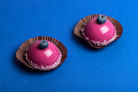 Purple mousse cakes on blue background top viewの写真素材