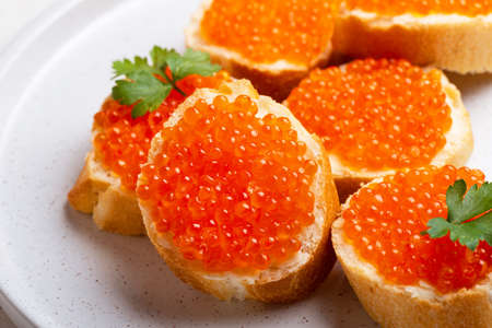 Delicious Sandwiches with red caviar on a white plate backgroundの写真素材