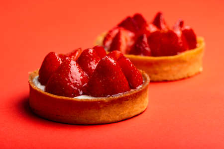 Strawberry tarts with custard on red background close-up macroの写真素材