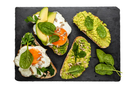 Sandwiches with avocado, spinach and fried eggs on a isolated backgroundの写真素材