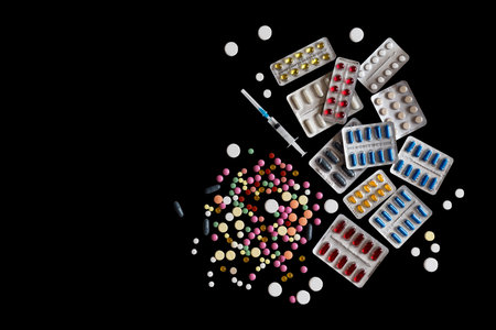 Different of blisters and colorful pills on a isolated black background flat lay copy spaceの写真素材